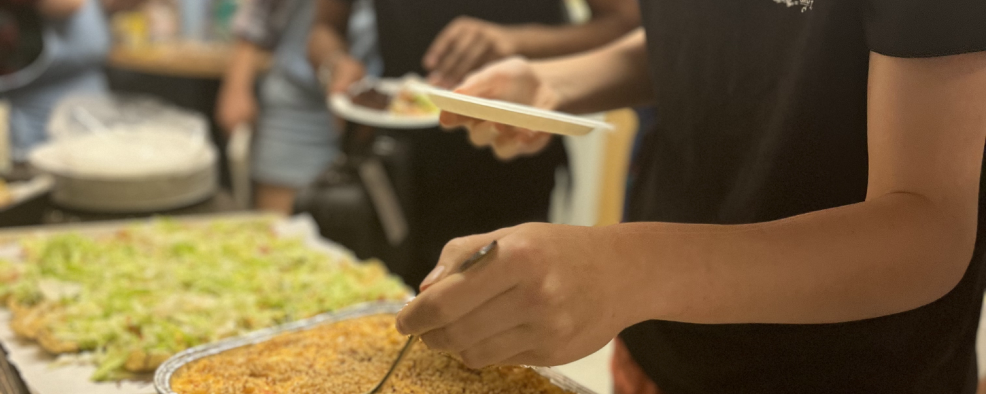Residents serving macaroni and cheese in Saffron Café